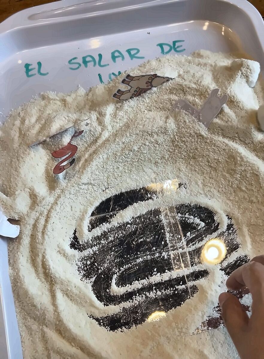 A white sensory tray with a mirror, recreating Bolivia's Salar de Uyuni