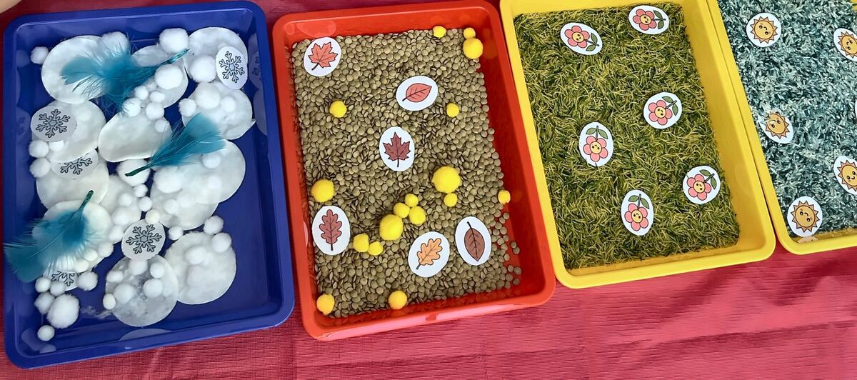 Four coloured sensory trays, one for each season